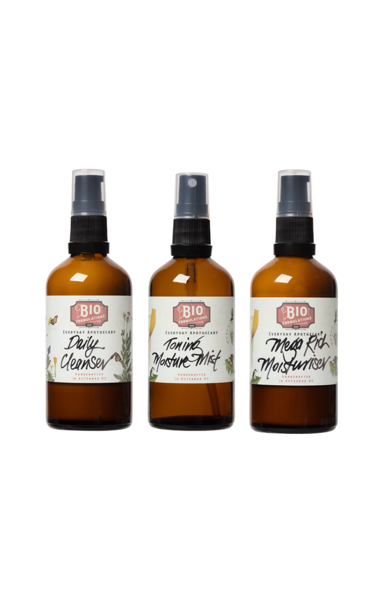 Three bottles of skincare products with labels on a white background